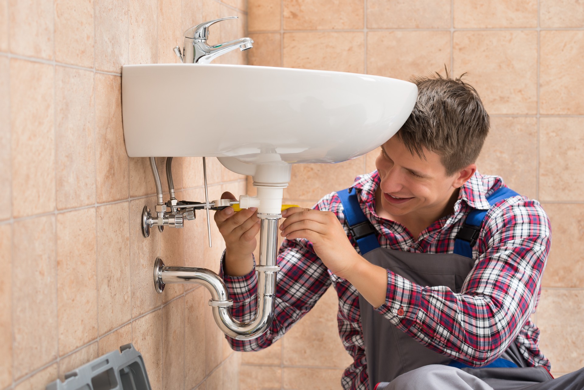 Smiling Plumber Repairing Sink